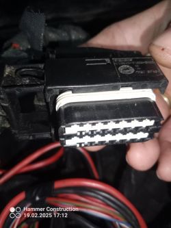 Złącze elektryczne trzymane w dłoni z widocznymi przewodami.