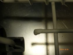 Wnętrze kosza zmywarki z widocznymi pokryciami ochronnymi.