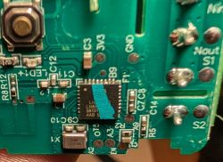 Close-up of a green PCB with an integrated circuit and soldered connectors