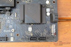 Zbliżenie na dolną część płyty głównej ASRock z widocznymi portami SATA i gniazdem M.2