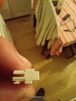 Zdjęcie białego złącza 3-pinowego trzymanego w palcach.