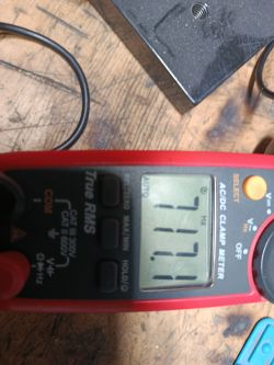 Multimetr pokazujący częstotliwość 177,1 Hz na drewnianym blacie