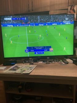 Telewizor Sony pokazujący mecz piłki nożnej między PSG a Barceloną.