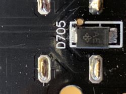 Zbliżenie PCB z elementem SMD oznaczonym D705 i widocznymi metalowymi padami lutowniczymi