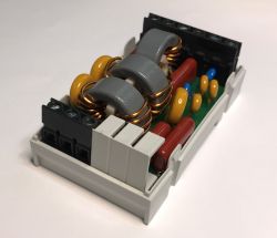Electronic interference filter with inductors and capacitors on a PCB.