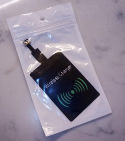 Wireless charger in packaging on a light background.