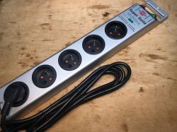 Power strip with six 230V Schuko sockets on a wooden surface