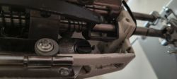 Zbliżenie mechanizmu maszyny z metalowymi prętami, sprężyną, śrubami i czarną dźwignią