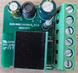Close-up of an electronic control module with capacitors, terminals, and model marking.