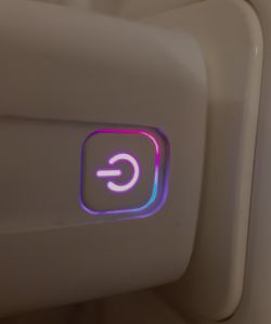 Power button icon on a plug with purple backlight.
