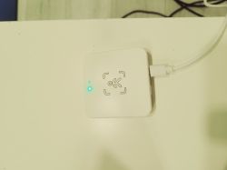White USB Adapter with LED White adapter with a blue LED and USB cable on a white surface.