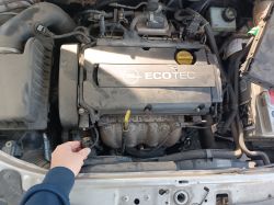Osoba trzymająca czujnik w komorze silnika z logo EcoTec na pokrywie.