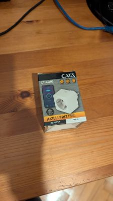 Packaging of the CATA CT-4010 smart plug on a wooden surface