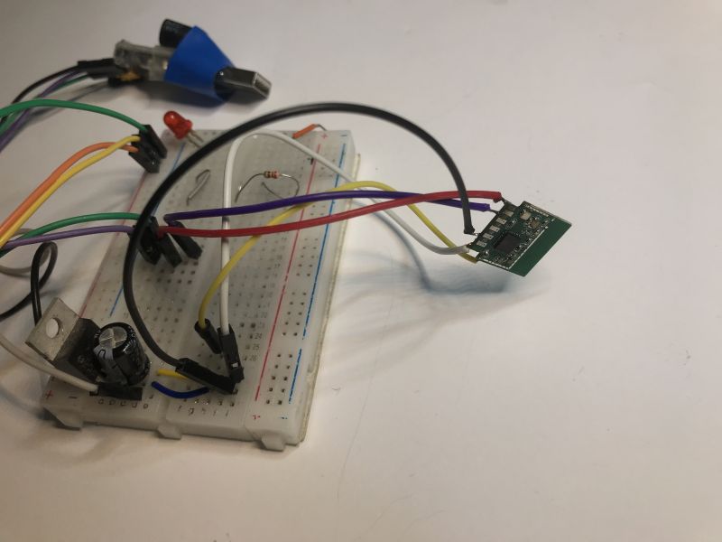 Electronic breadboard with multicolored wires and components.