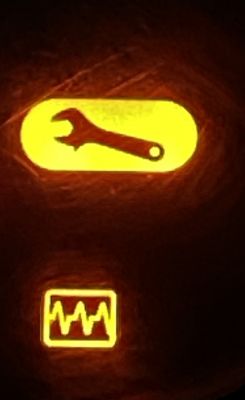 Illuminated dashboard icons: wrench and graph.