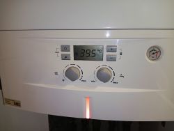 Panel sterowania pieca gazowego Junkers pokazujący temperaturę 39,5°C oraz manometr wskazujący ciśnienie 3 bar.