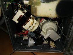 Wnętrze zmywarki Mastercook ZWE-1445X z widocznymi komponentami elektrycznymi i hydraulicznymi.