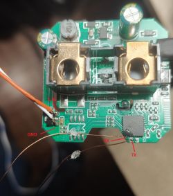 Close-up of a circuit board with labeled 3.3V, GND, RX, and TX ports and connected wires.