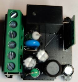 Circuit board with green connector and various electronic components.
