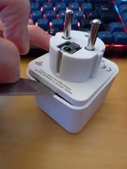 Opening a Smart Plug with a Blade A person opens the casing of a smart plug using a narrow blade.