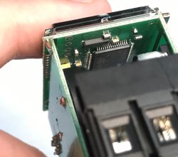 Zbliżenie na moduł elektroniczny z widoczną płytką PCB, układem scalonym i złączem.