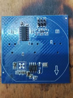 Blue PCB with mounted integrated circuits, connectors, and a quartz crystal.
