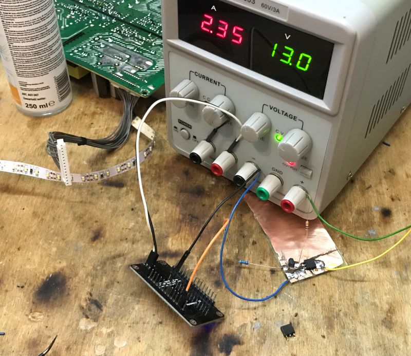 Prototype Circuit with MOSFET and ESP8266 Electronics lab with power supply, ESP8266 board, and prototype circuit.
