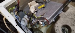 Obraz wnętrza pralko-suszarki Whirlpool z widocznym modułem elektrycznym i przewodami połączeniowymi.