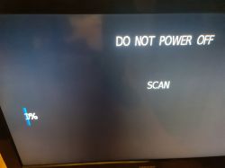 Ekran telewizora z komunikatem o skanowaniu i instrukcją DO NOT POWER OFF.
