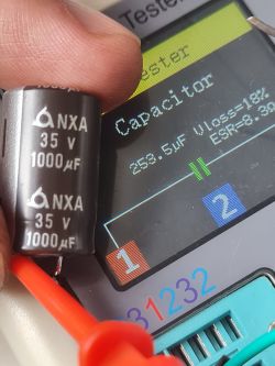 Zbliżenie na kondensator elektrolityczny NXA 35V 1000µF i wynik pomiaru na testerze.