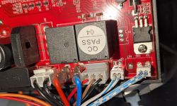 Close-up of an electronic circuit board with multicolored wires connected to terminals.