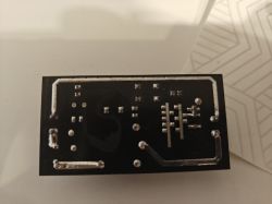 Bottom Side of Circuit Board with Metallic Traces View of the bottom side of a black circuit board with metallic traces and solder points.