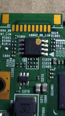 Zbliżenie układu scalonego na płytce PCB z pomarańczową plamką na obudowie