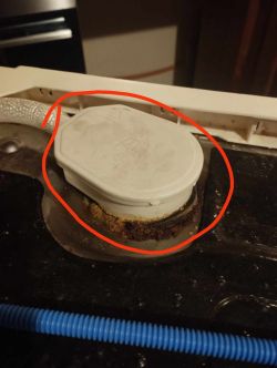 Biały plastikowy element w otoczeniu korozji i zaznaczony na czerwono