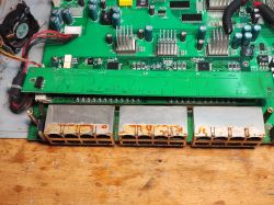 Zbliżenie na płytę główną starego switcha sieciowego z widocznym modułem portów Ethernet, na których widoczna jest rdza i ślady korozji.