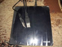 Czarny napęd optyczny ze złączami USB na dywanie.
