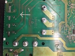 Widok płyty drukowanej z widocznymi ścieżkami i elementami elektronicznymi oraz śladami naprawy.