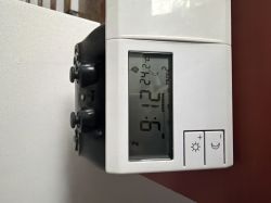 Wyświetlacz termostatu z temperaturą 24,2°C na programie 2 Termostat ścienny pokazujący temperaturę 24,2°C i godzinę 9:12