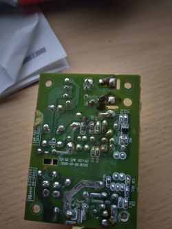 Zdjęcie płytki drukowanej z elementami elektronicznymi na drewnianym biurku.