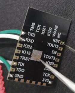 Close-up of an electronic module with visible pins labeled as TMS, TCK, IO21, IO20, and others.