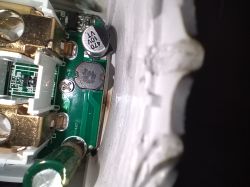 Close-up of an electrical socket interior with a circuit board and electronic components visible.