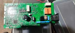 Zdjęcie płytki drukowanej z widocznymi elementami elektronicznymi, w tym wypalonym elementem.