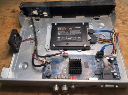 Wnętrze metalowej obudowy z płytą PCB i dyskiem SSD Samsung 870 EVO 4TB, okablowanie i wentylator.