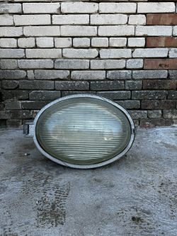 Przemysłowa lampa PREDOM-MESKO OURP-250 na tle ceglanej ściany.