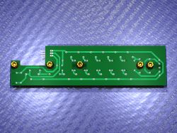View of a printed circuit board with sockets and conductive traces on a blue background.