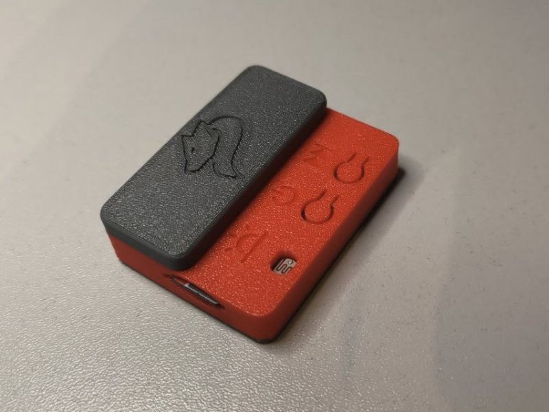 Small device in a red and black casing with two buttons and a USB Type-C port.