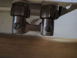 Metal radiator valve against a wall and floor background.