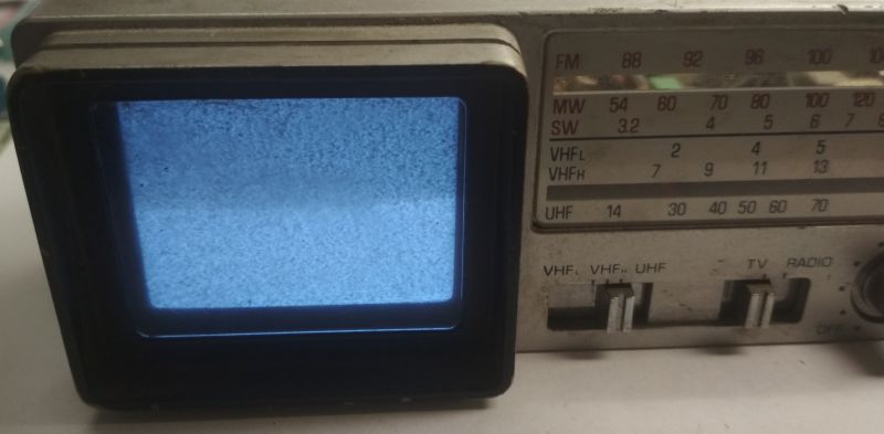 Mini telewizor Broksonic CIRT-2097T z wyświetlanym szumem na ekranie i panel kontrolny z przodu.