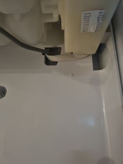 Zbliżenie wnętrza kostkarki lodu z widocznym przetarciem szarego kabla.