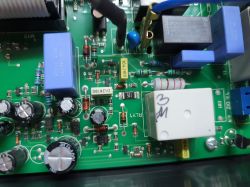 Close-up of a circuit board with components like capacitors, resistors, and relays.